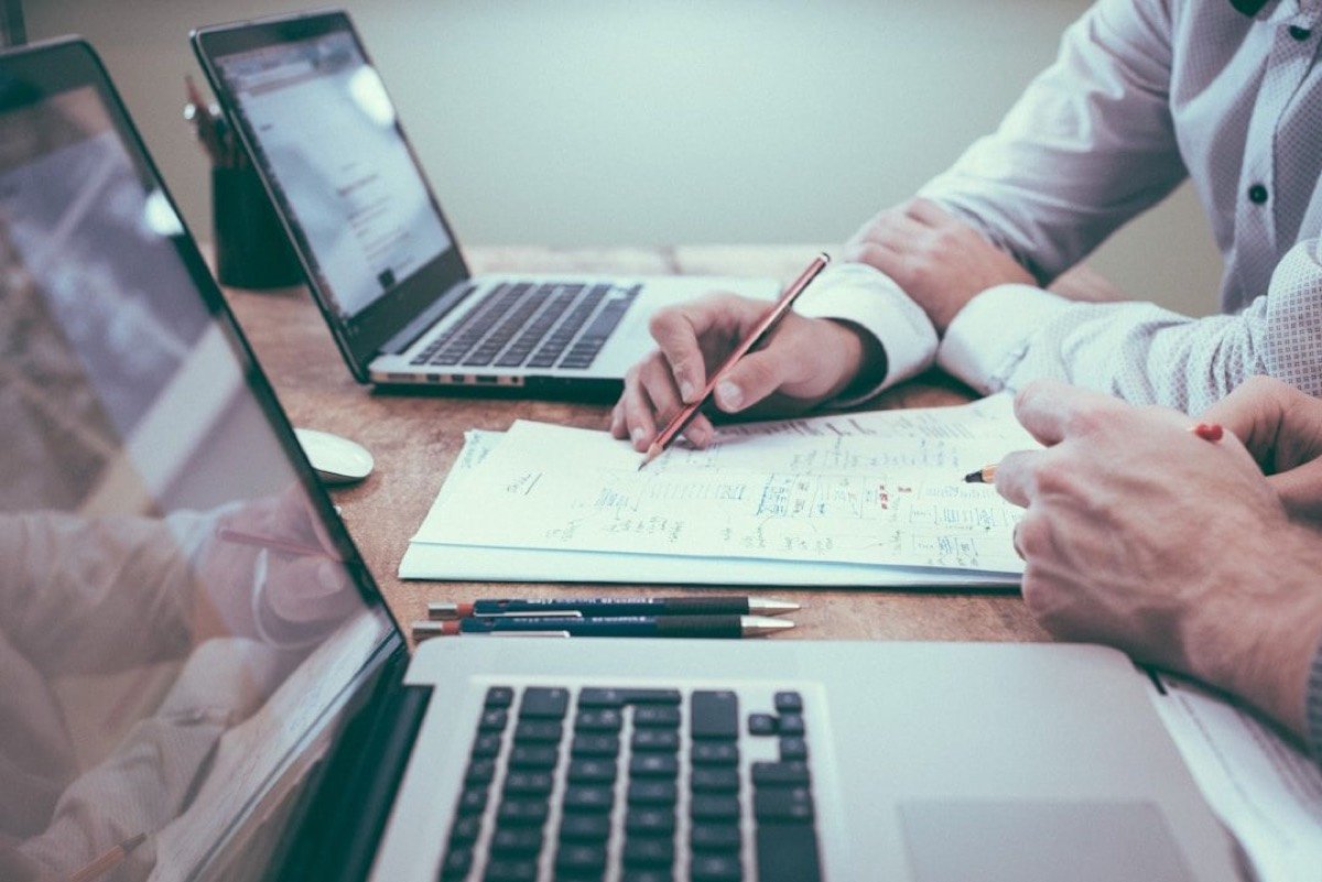 Twee mensen werken samen aan cijfers op een laptop