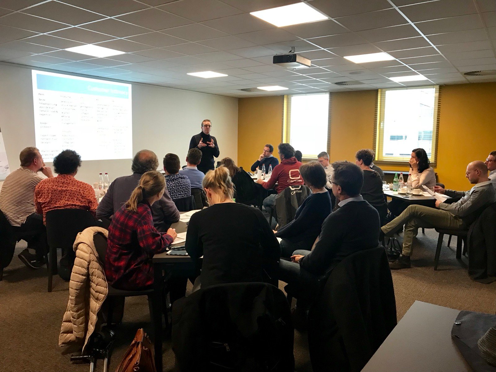 Volle zaal met deelnemers aan een strategieworkshop voor KMO-bedrijfsleiders
